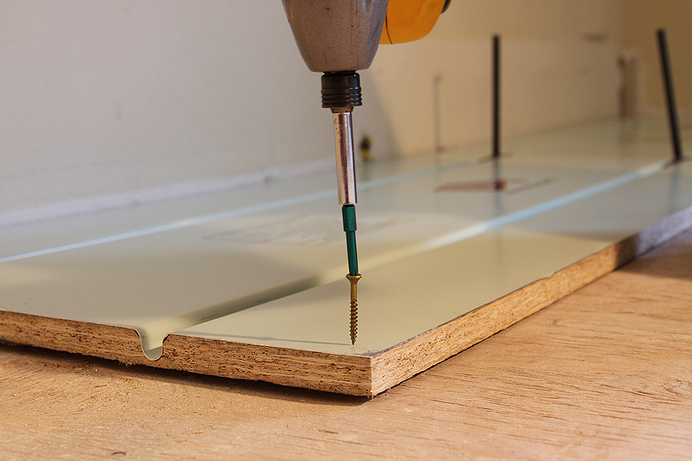 Screwing a Warmboard-R panel down to the existing floor