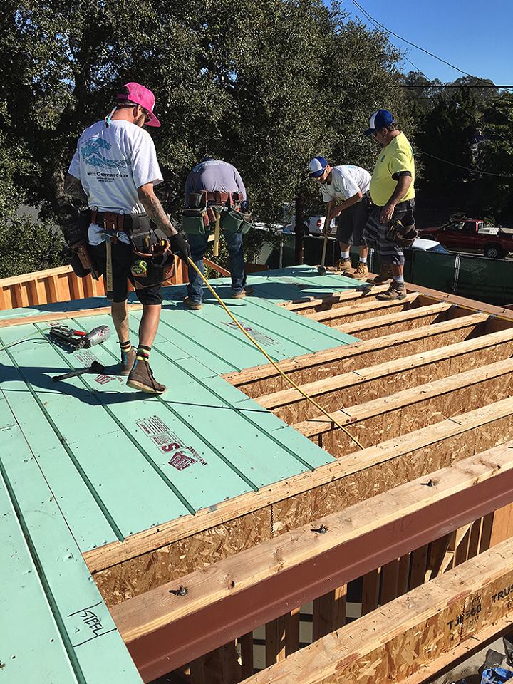 Builders laying Warmboard-S panels over floor joists on site