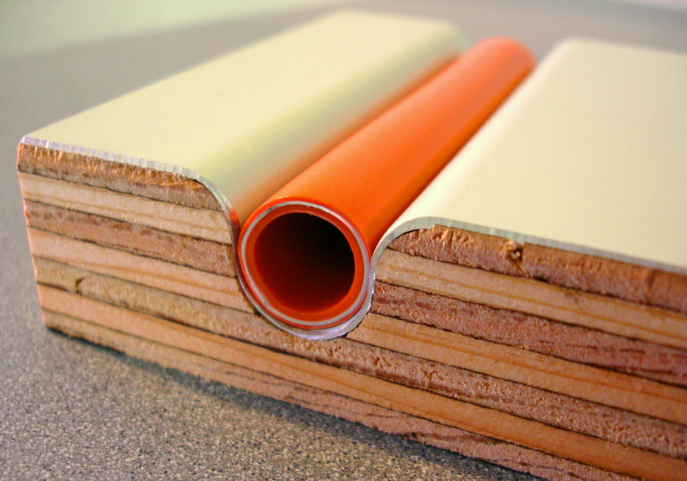 Cross-section of a Warmboard-S plywood panel showing the pipe in its aluminium-faced channel